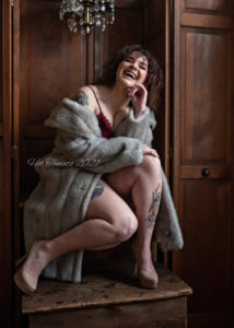 Marietta Ohio boudoir client photographed in a fur coat with a huge natural laugh.